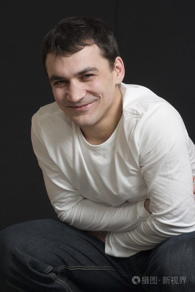 一个开朗的男人在黑色背景下微笑的肖像.