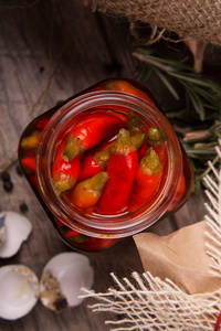 红辣椒 papper 的特写在一个玻璃瓶, 迷迭香的绿色小树枝和鹌鹑蛋的空斑点贝壳, indredients 的美味佳肴的木制背