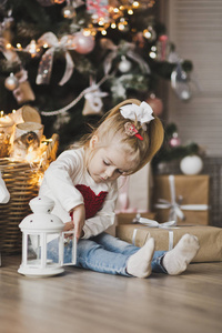 一个小女孩坐在圣诞树下的礼物7236