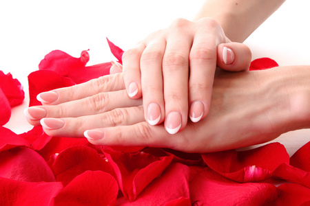 美丽的女人手上有法国指甲和玫瑰花瓣的圆周率