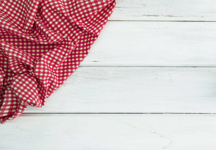 皱巴巴的红色格子桌布或餐巾在空白的白色木头