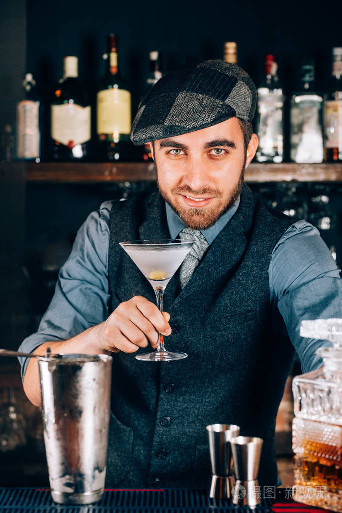 英俊老式酒保准备干马丁尼和服务客户