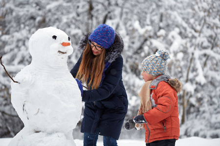 冬天的乐趣。一个女孩和一个男孩在做雪球