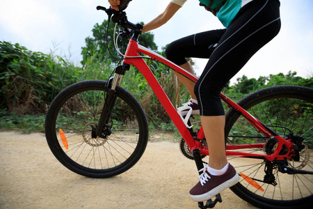 车步道年轻女子骑山地自行车在森林步道上照片