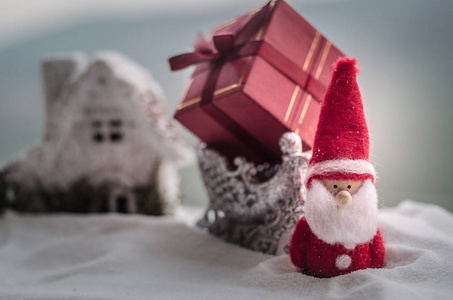 红色圣诞节礼物箱子和冷杉树在雪。圣诞节家庭装饰与雪和树在模糊的背景在白天与复制空间。选择性焦点