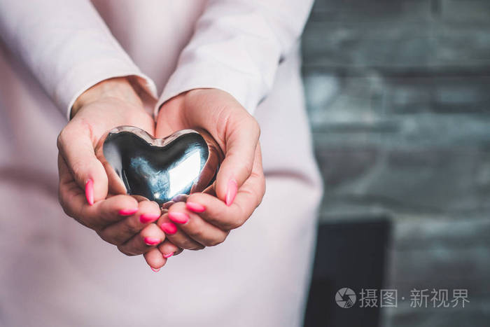 女人握在她的手心里手和心脏接近腹部新的生活怀孕一个小男人的新心脏