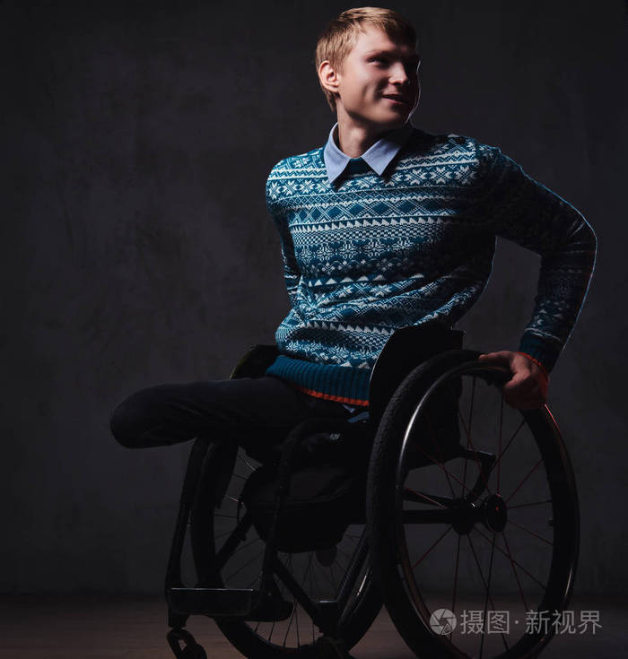 一个在灰色背景下坐在轮椅上的男人