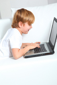 小男孩在家里用笔记本电脑