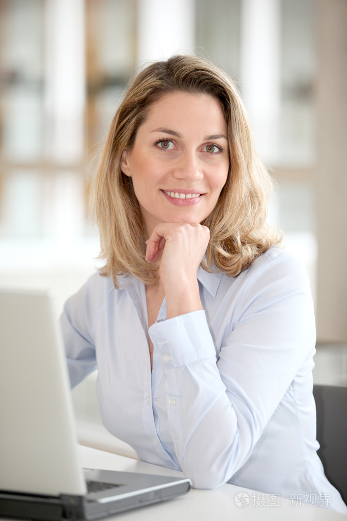 手提电脑前微笑的上班族