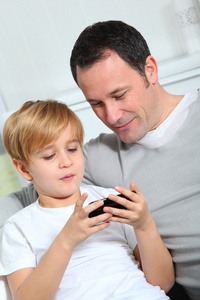 父亲和儿子在家玩电子游戏
