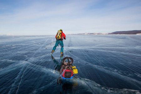 带背包的雄性徒步旅行者在冰水表面行走, 俄罗斯, 贝加尔湖