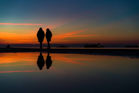 两个女人剪影在海边漫步的倒影, 基督徒照片