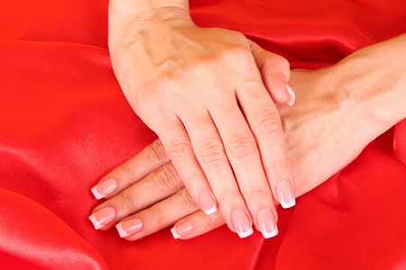 红色背景的法国美甲美女双手