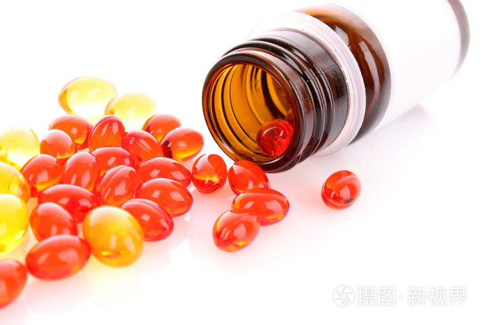 白色背景下的红色和黄色维生素胶囊