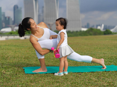 亚洲华人妇女在户外练习瑜伽与年轻女婴