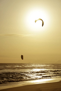 里约热内卢日落海洋中的 Kitesurfers 骑浪