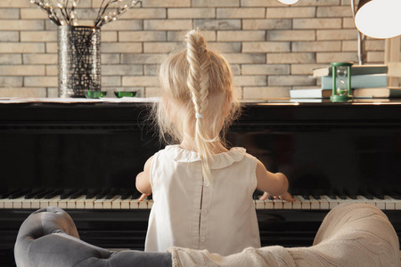 在室内弹钢琴的小女孩照片