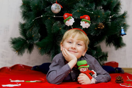 圣诞节前圣诞树上摆着圣诞饰品的小男孩
