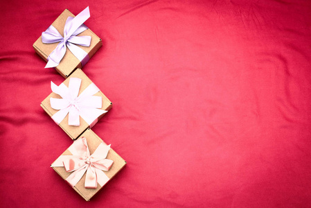 三礼品盒绑在红色的背景色缎带红色的心