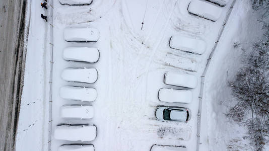 Aerila 观看雪覆盖的汽车站立在停车场在冬天天