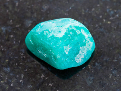 暗花岗岩背景下的 amazonite 宝石