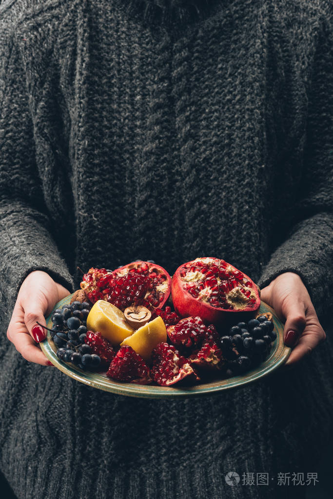手里拿着水果的妇女盘子