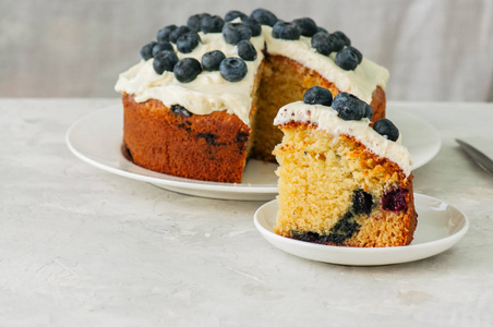 酸奶油和蓝莓蛋糕在一块白色石头的盘子上服务