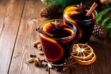 圣诞节的两杯葡萄酒的时候用桔子和木制背景上的香料