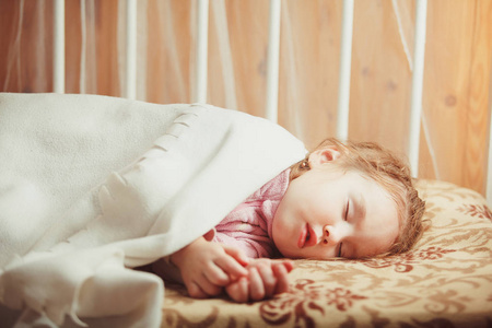 女孩睡在毯子下。日间睡眠孩子