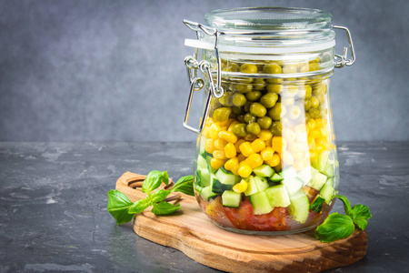蔬菜黄瓜西红柿豌豆和玉米罐中的健康自制沙拉健康饮食排毒纯食物或素食概念