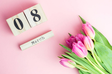 3月8日幸福妇女节的概念。与木制方块日历和粉红色的郁金香背景粉红色