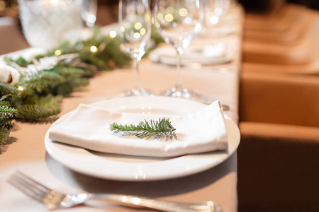 圣诞大餐带香槟眼镜和背景圣诞树的装饰餐桌