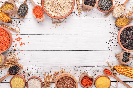 荞麦, 扁豆, 大米, 小米, 大麦, 玉米, 黑米.在一个白色的木制背景.