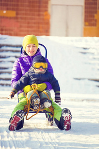 妈妈带着小孩坐雪橇