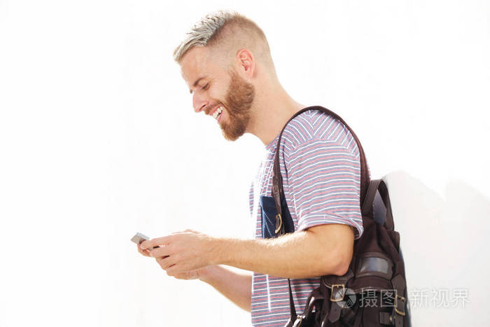 酷年轻人的侧面肖像与胡子看着手机