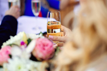 女人的手与香槟玻璃在正式仪式上
