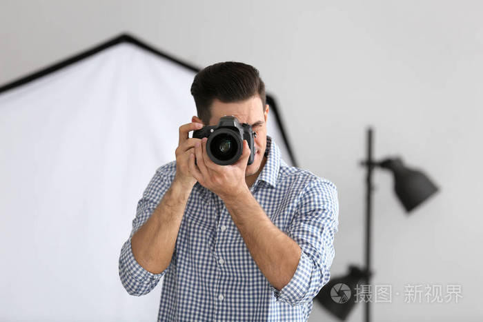 年轻摄影师在专业工作室拍照