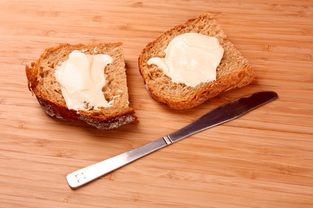 刀法和木质表面上奶油面包