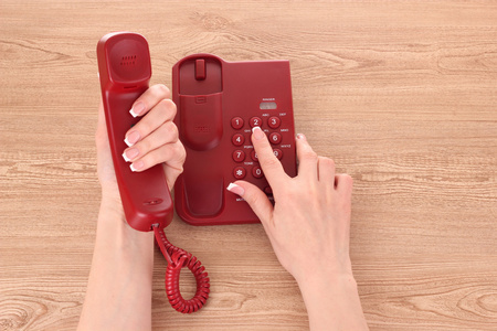 红色电话和木桌上的手