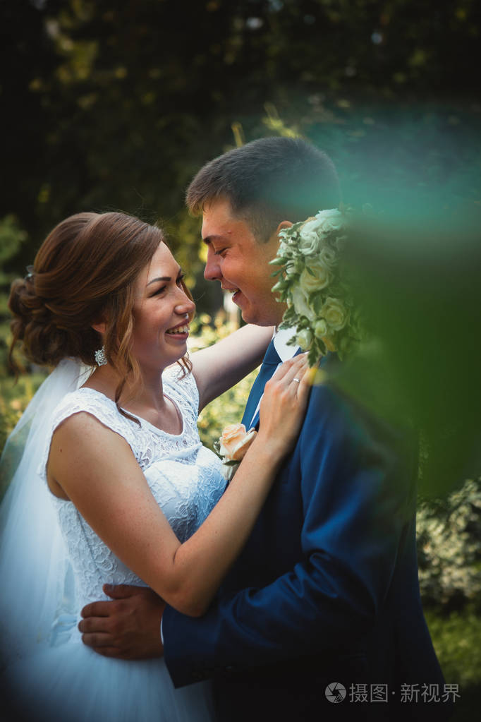 几个新郎和新娘拥抱和亲吻就自然公园背景