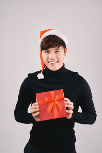年轻英俊的亚裔男子与圣诞老人帽子藏品礼盒