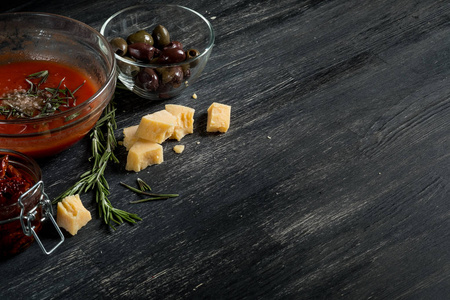 意大利香肠, 橄榄, 芝士和番茄酱, 配有复印空间的黑木桌