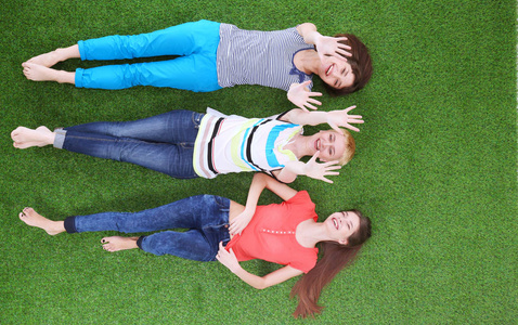 年轻的妇女躺在绿色的草地上。年轻妇女