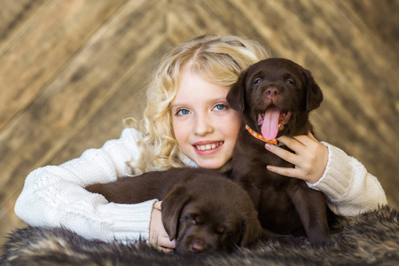 可爱的小女孩拥抱可爱的黑小狗