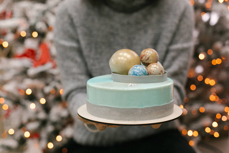在女性手中的巧克力球顶部的圣诞蛋糕视图