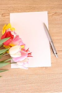 木桌上的郁金香和纸图片