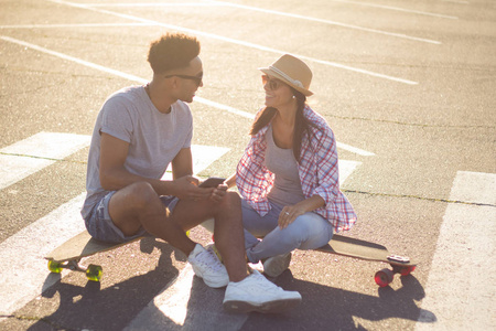 快乐的年轻夫妇与滑板, 幸福的概念, 爱和青年时期