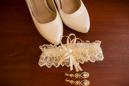 新娘鞋, 耳环和吊袜带的婚礼配件。婚礼上午