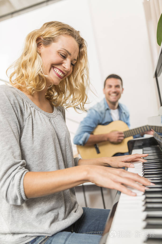 吉他手伴奏的年轻钢琴演奏家