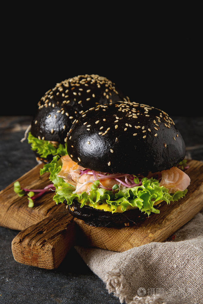 黑色汉堡配三文鱼, 生菜, 芥菜.黑暗的背景照片-正版商用图片03d5ty-